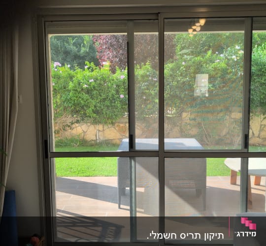 חלון זכוכית עם נוף לגינה ירוקה